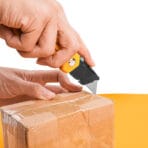 Hand cutting a cardboard box with a Tolsen utility knife