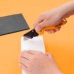 Utility knife by Tolsen demonstrating its cutting performance on white foam