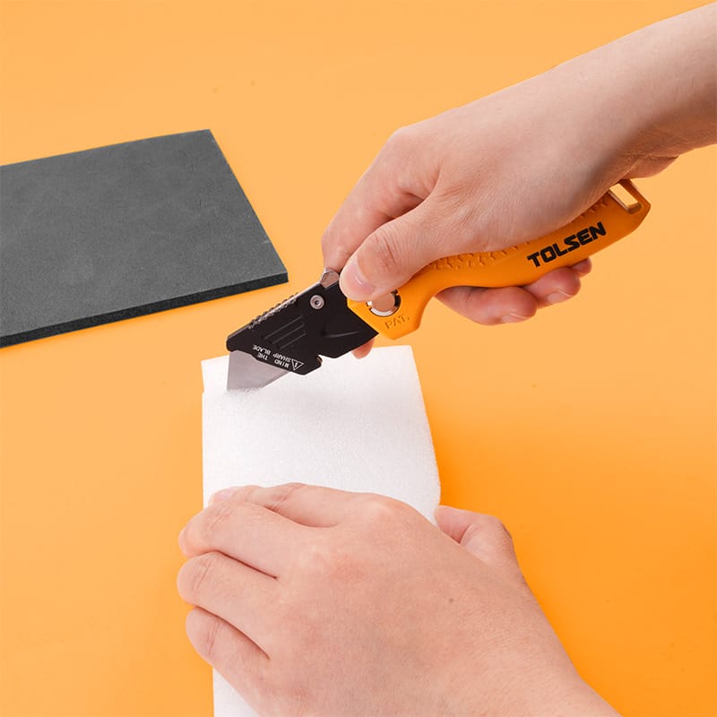 Utility knife by Tolsen demonstrating its cutting performance on white foam
