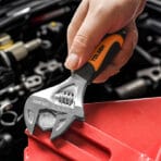 Close-up of a hand using a Tolsen 6.5-inch stubby adjustable wrench to turn a bolt