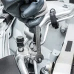 Mechanic using a TOLSEN combination wrench for automotive engine repair in a tight space