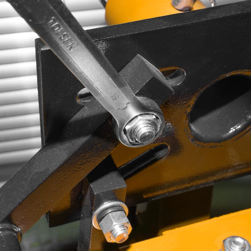Close-up of a TOLSEN ring spanner tightening a nut on a heavy metal frame structure