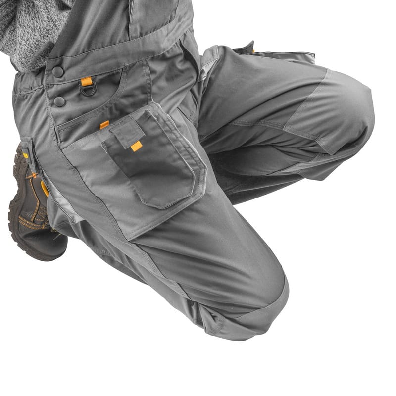Worker kneeling in Tolsen overalls, demonstrating the flexibility and utility of the reinforced knee areas.