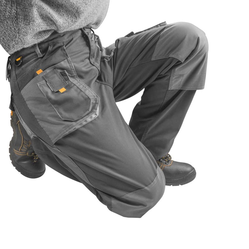Model kneeling in Tolsen work pants, demonstrating flexibility and the utility of the reinforced knee areas.