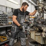 Professional worker operating machinery while wearing durable Tolsen working overalls for safety and protection.