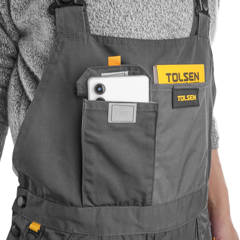 Tolsen overalls chest pocket shown holding a smartphone and notebook, highlighting practical storage solutions.