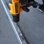Tolsen 12V Cordless Drill drilling into metal track
