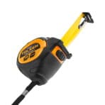 Dynamic angle of Tolsen 5m measuring tape showing the extended blade, metallic end hook, and robust casing.