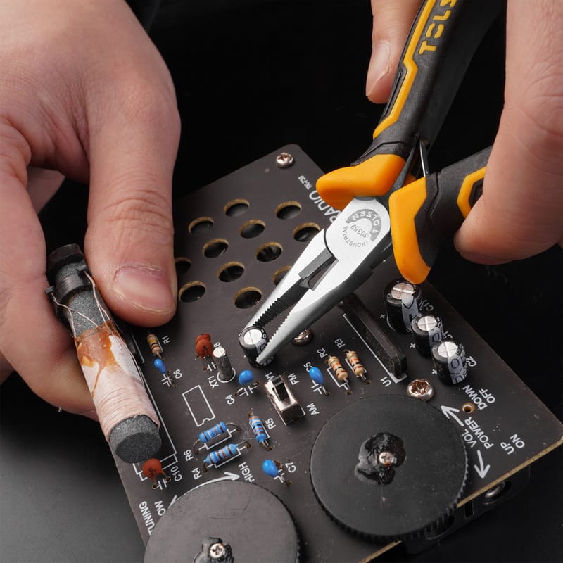 Using Tolsen precision pliers to carefully hold small components during a radio repair.