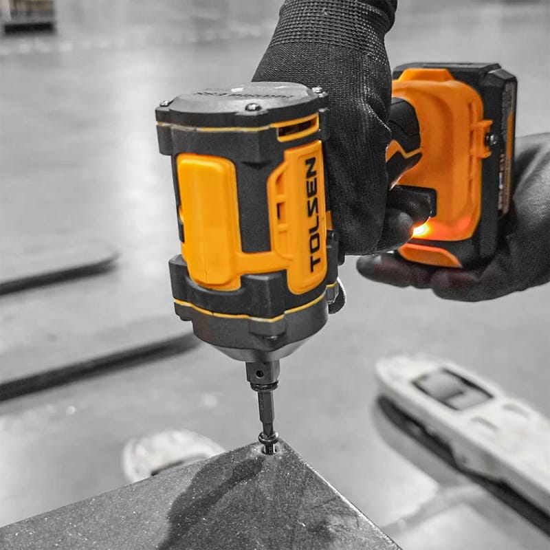 A person using a Tolsen 20V brushless cordless impact wrench to drive a screw