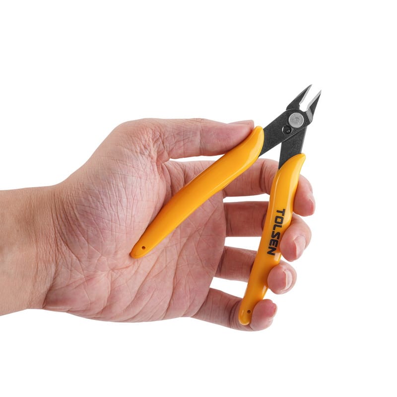 A hand holding the compact TOLSEN 5-inch diagonal flush cutter, demonstrating its small size which is ideal for precision electronic, zip tie, and craft work.
