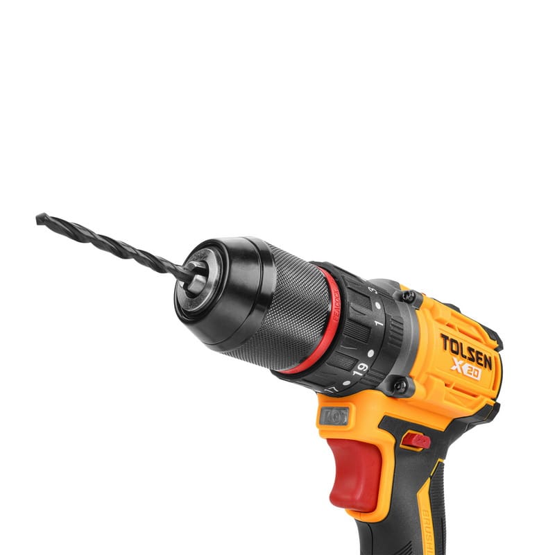 Close-up angled view of the TOLSEN hammer drill with a black twist drill bit securely fastened in the heavy-duty 1/2-inch keyless metal chuck.